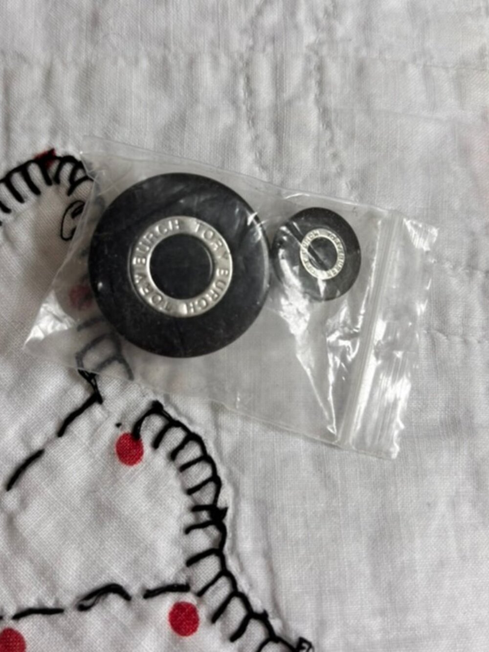 Tory Burch black round buttons featuring silver-tone hardware branded with logo